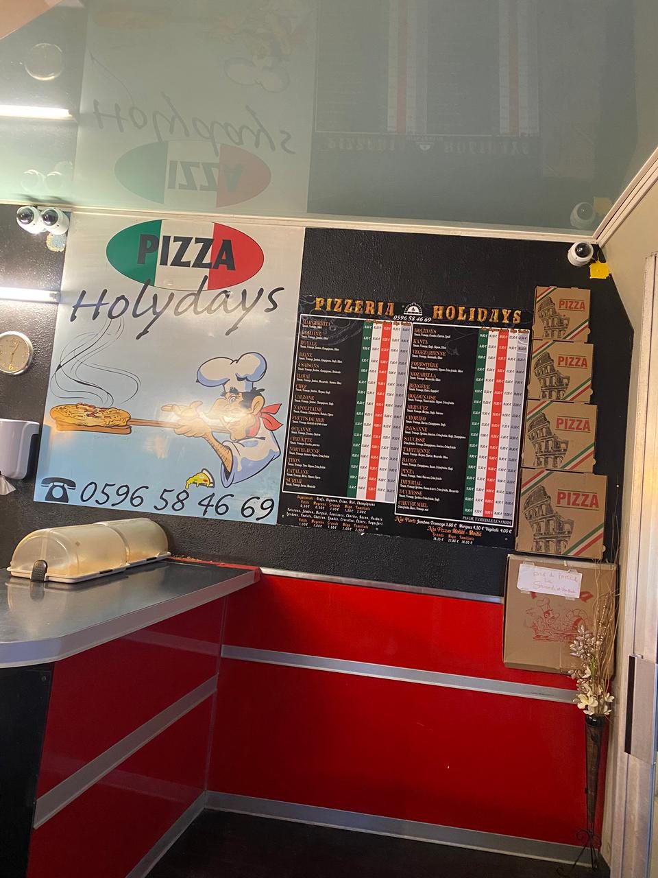 Le comptoir et le logo de Holydays Pizza